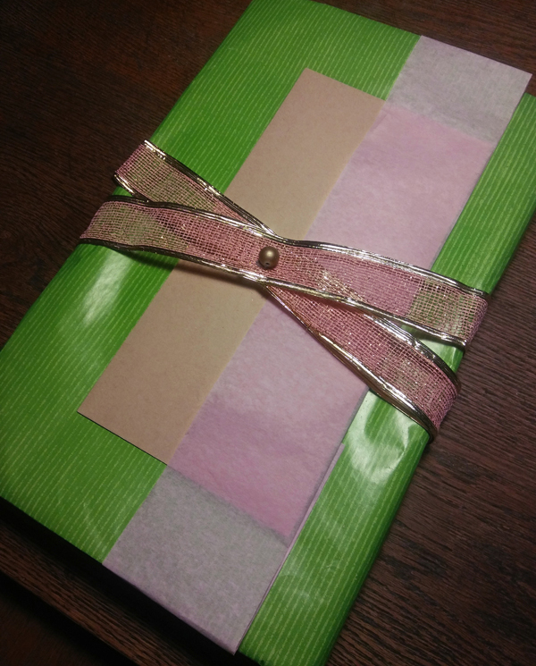 Portret zapakowany w zielony papier i różową wstążkę